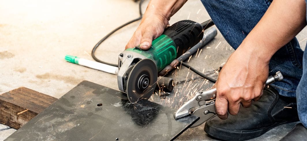 man operating a angle grinder and adjustable spanner wrench for cutting steel plate concept personal injury accidents and injury at work client
