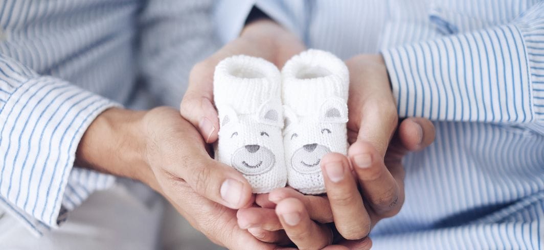 man and pregnant women holding baby shoes concept medical negligence serious incident reports mini banner