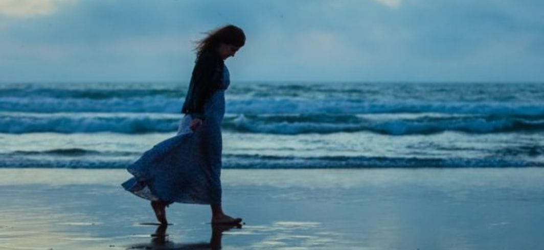 woman walking bare foot across the beach concept criminal injury sexual abuse client