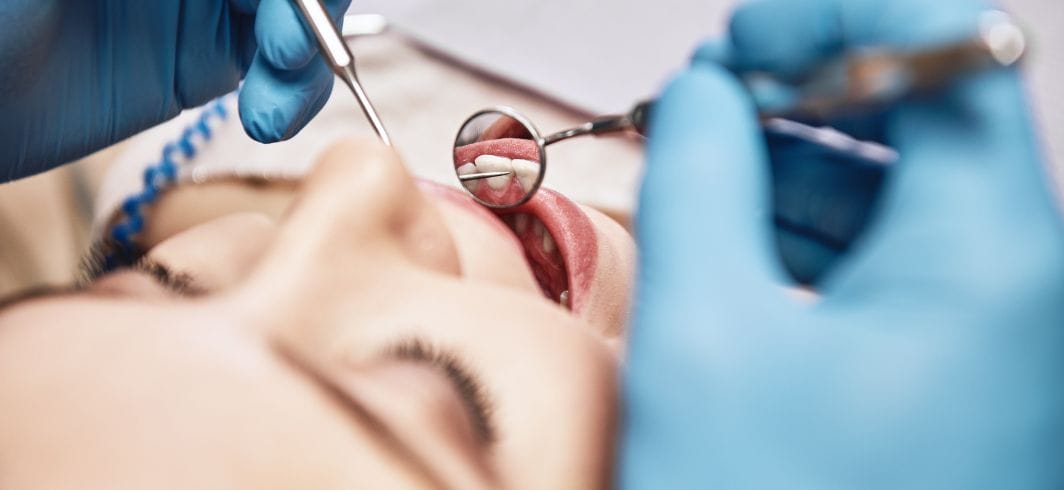 dentist examining patients teeth in clinic concept representing medical negligence dental negligence compensation claims