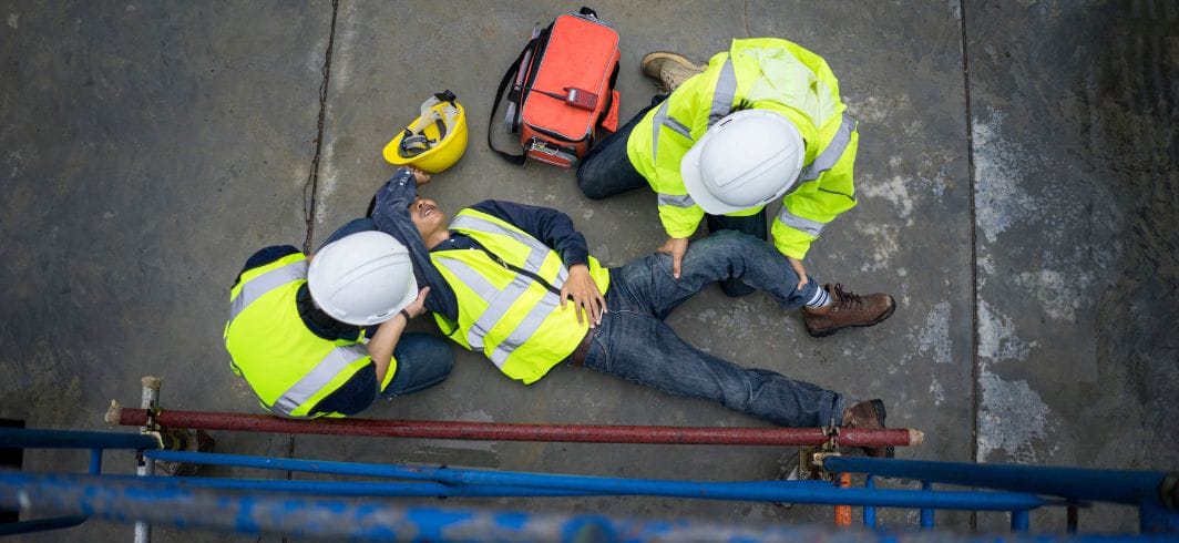 man receiving first aid treatment after an accident at work concept personal injury fall at work accident at work banner