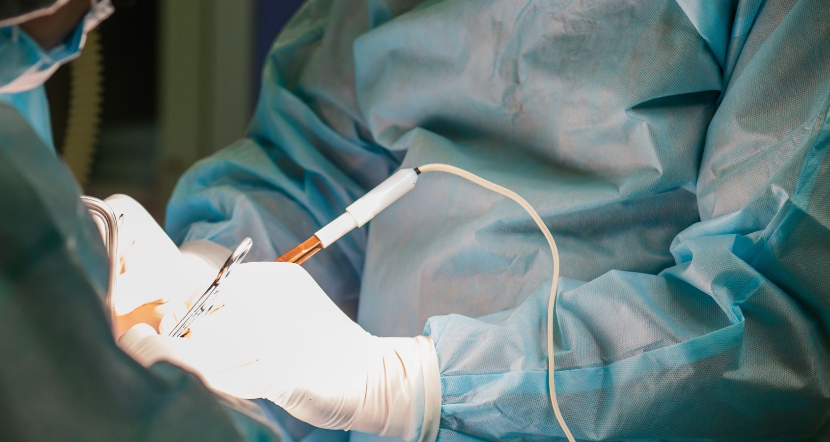 close up image of surgeon and assistant performing cosmetic surgery in hospital operating room doctor holding surgical instrument concept medical negligence cosmetic surgery claims banner