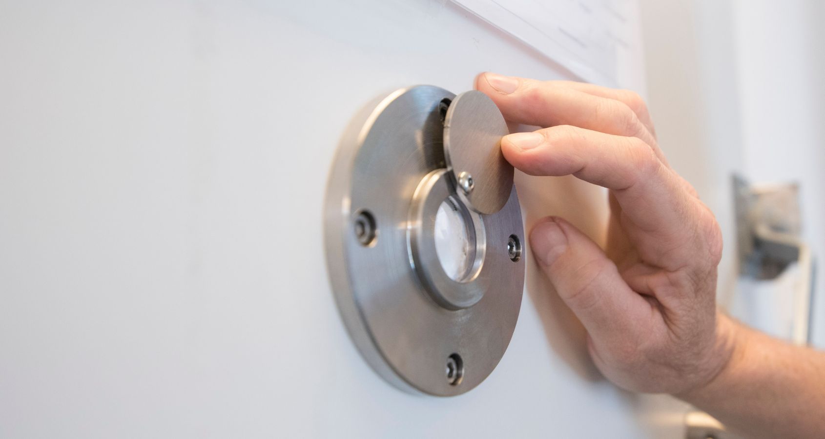 hand-sliding-back-peephole-of-prison-door-concept-representing-civil-liberties-prison-compensation-claims