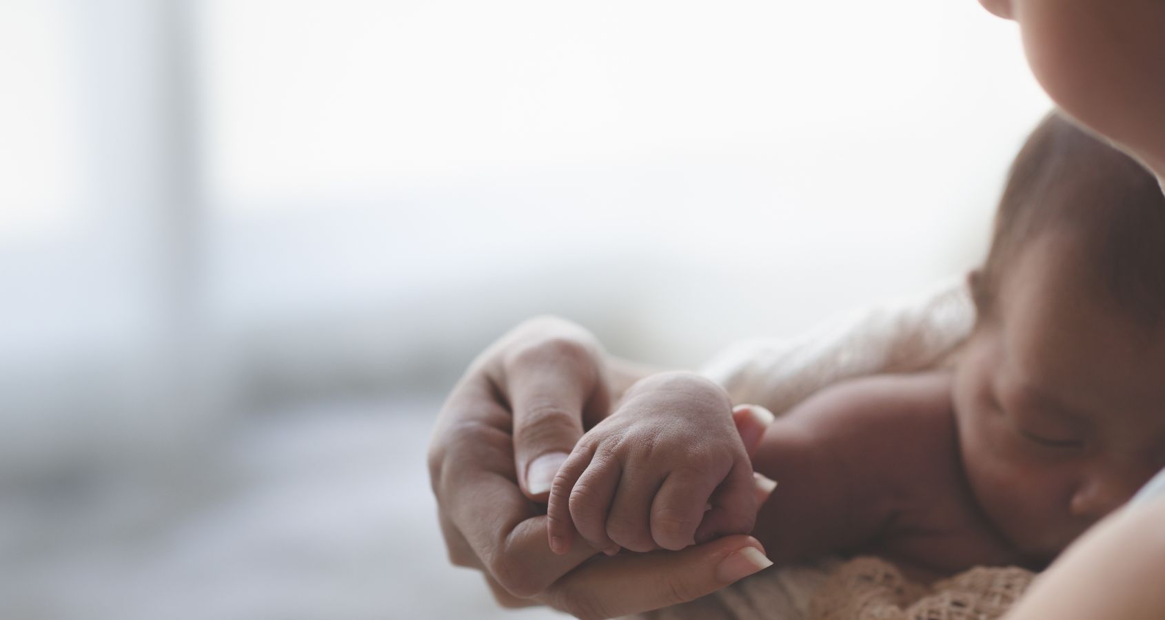close-up-mother-holding-hands-asian-female-newborn-baby-and-sunlight-in-the-morning-concept-representing-medical-negligence-stillbirth-and-neonatal-compensation-claims