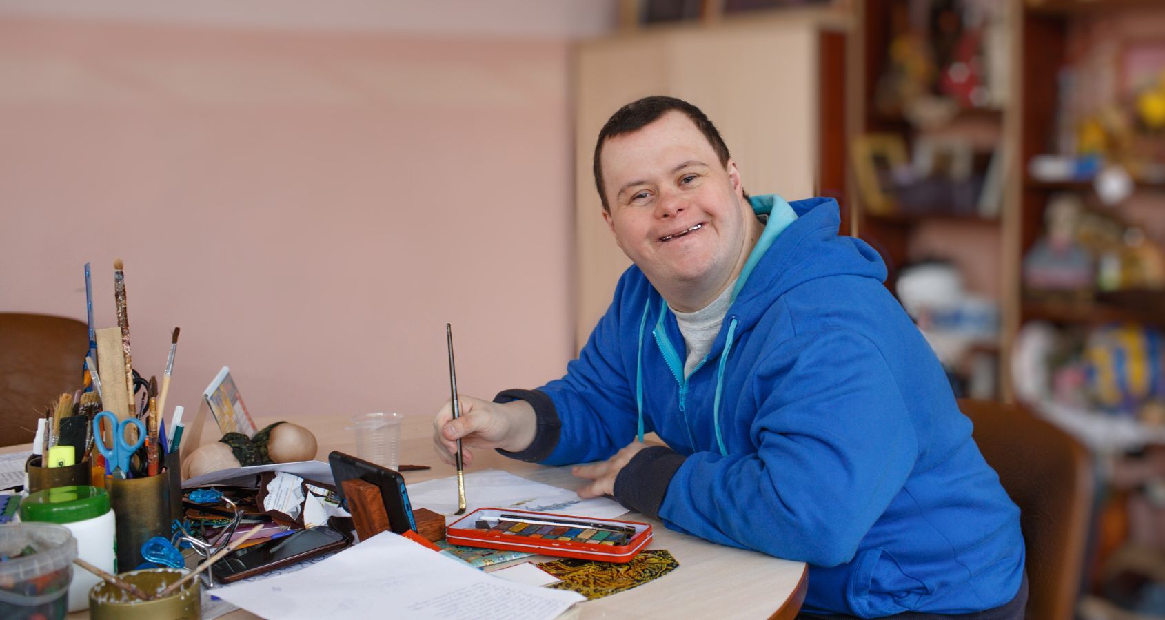a-man-with-down-syndrome-is-engaged-in-drawing-in-a-workshop-concept-court-of-protection-deputyships-statutory-wills-lasting-power-of-attorney-hero-banner
