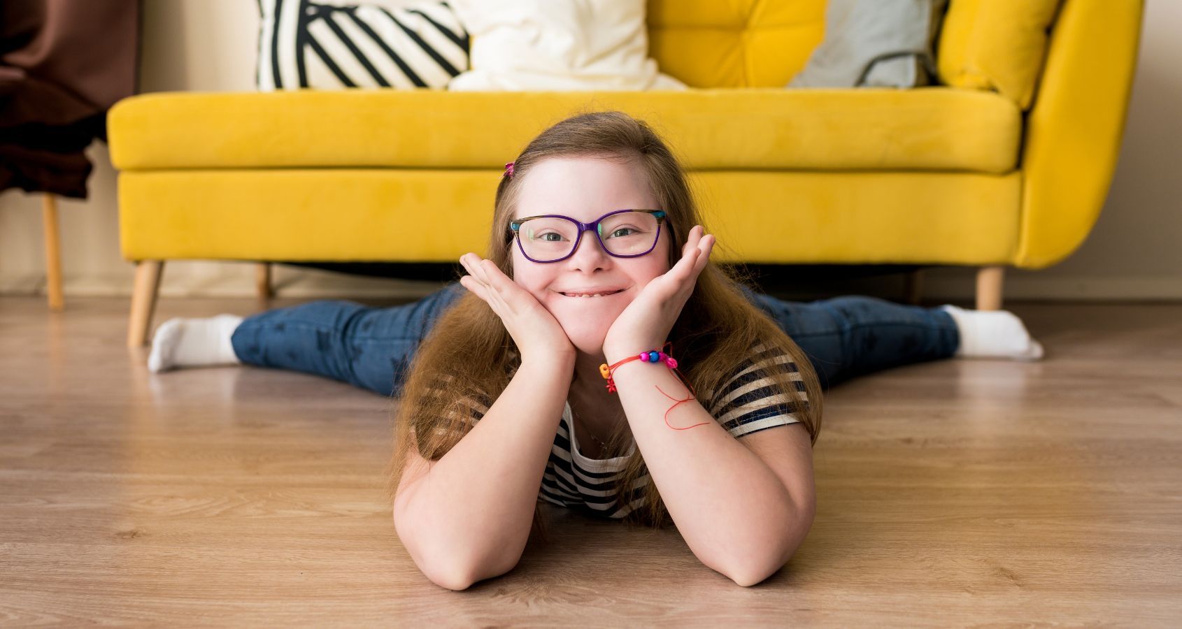 portrait of smiling teenager girl with down syndrome lying on the floor at home concept court of protection deputyships statutory wills lasting power of attorney hero banner