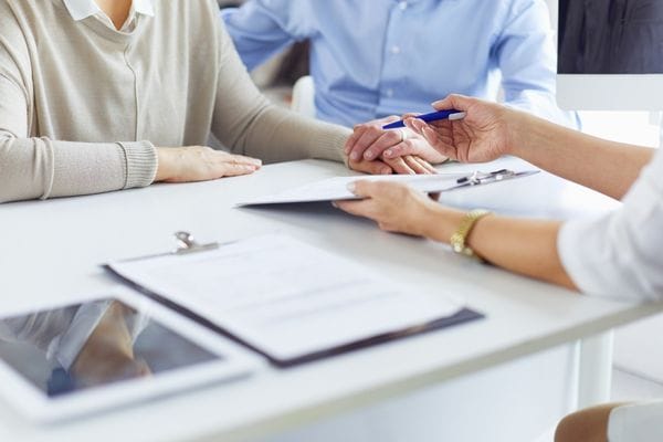 legal forms being signed by clients in an office
