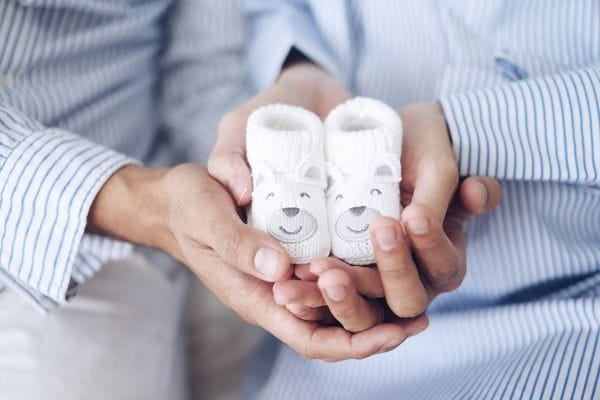 parents holiding baby booties in their hands