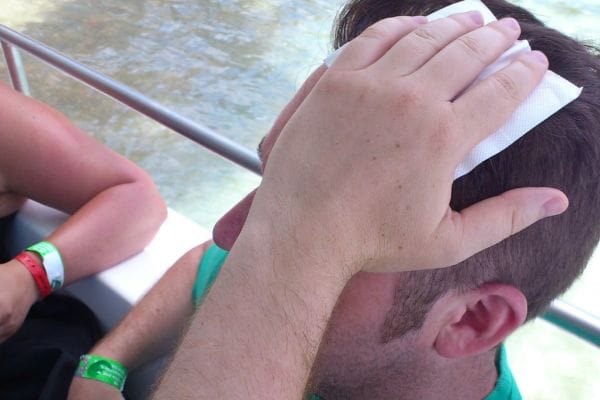 man holding gause to head injury whilst on a boat trip needing 8 stitches representing injurt abroad compensation claims
