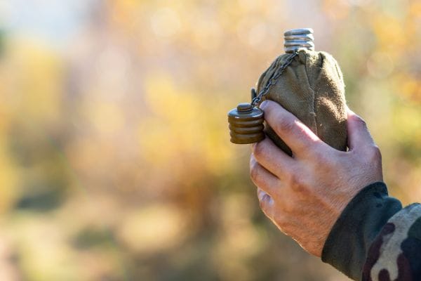 soldier outdoor camping holding water canteen representing military injury claims compensation claims