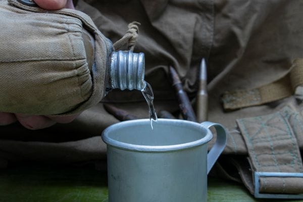 army-canteen-pouring-out-water-into-a-cup-representing-water-contamination-at-camp-lejeune-compensation-claims