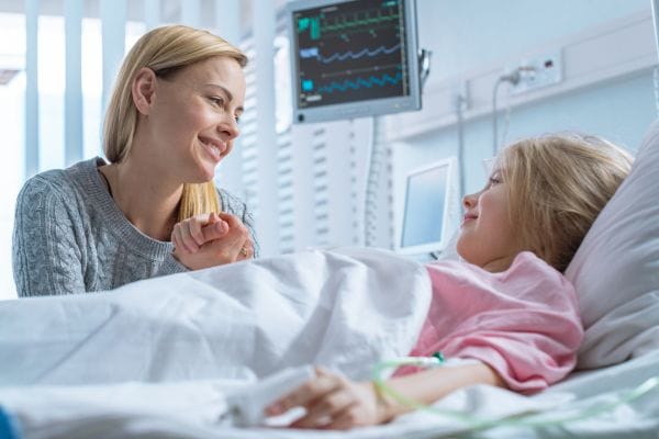 little-girl-lies-on-a-bed-in-the-childrens-hospital-her-mother-sits-beside-concept-representing-medical-negligence-meningitis-misdiagnosis-compensation-claims