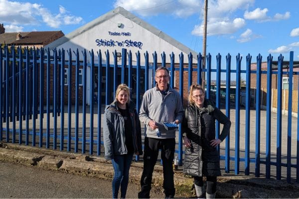 hudgell members painting fence for stick and step supporting children with cerebral palsy
