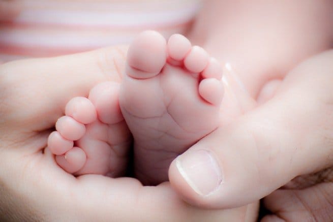 Adult holds baby's feet
