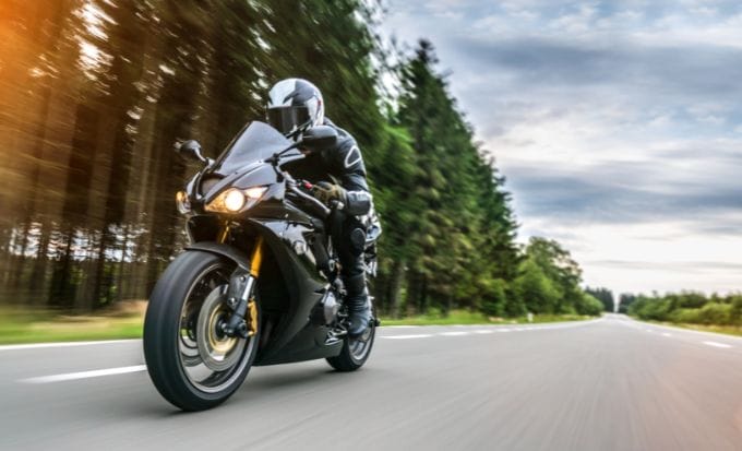 person riding a motorbike down an empty road concept personal injury motorcycle accidents feature (2)