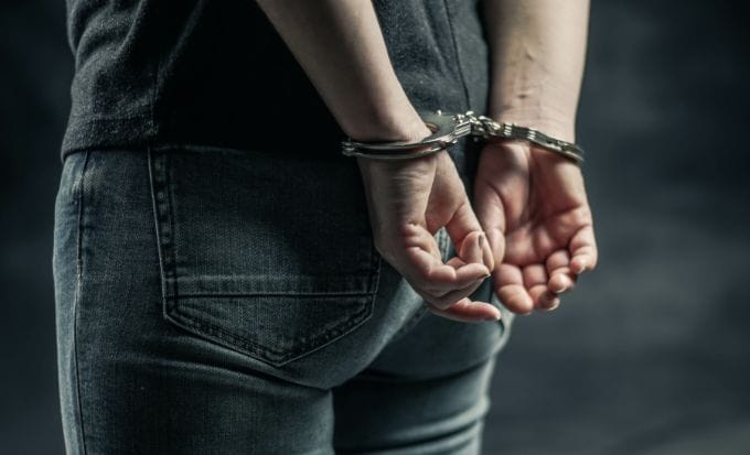 person with their hands handcuffed behind their back concept civil liberties wrongful arrest feature