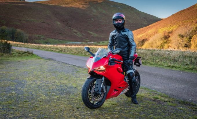 red motorbike with rider in upper coquetdale northumberland on a sunny day concept personal injury motorcycle compensation claims