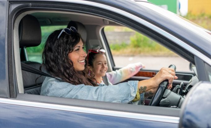 smiling mother and daughter sitting in car concept child injury car passenger road traffic accident feature image