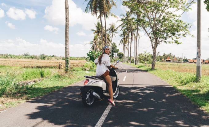 stylish young woman driving motorbike on road in tropical country concept serious injury abroad accident on holiday compensation claim