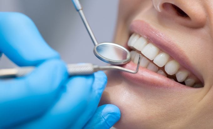 woman having her teeth checked by a dentist concept medical negligence dental negligence feature