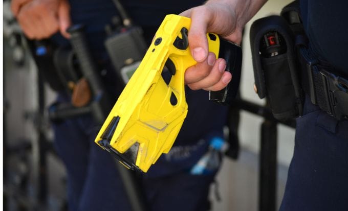 police officer holding a taser gun concept civil liberties actions against the police feature