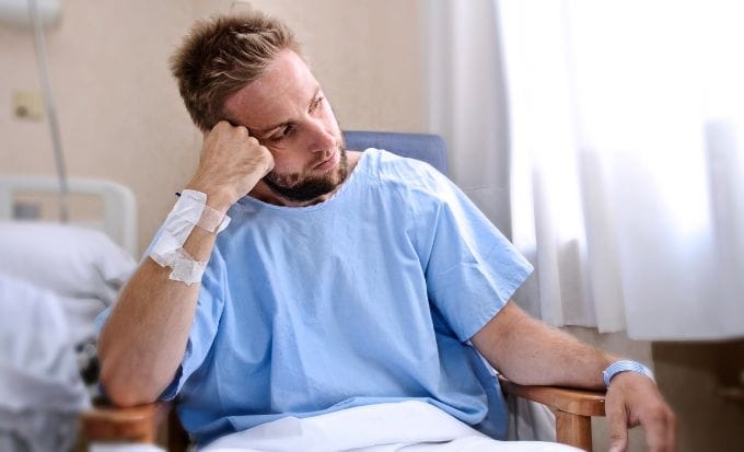 man sat by his hospital bed concept medical negligence fatal medical negligence feature