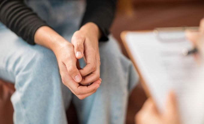 a female patient holds her hand while seeking consultation with a psychologist concept criminal injury sexual abuse compensation claims feature image