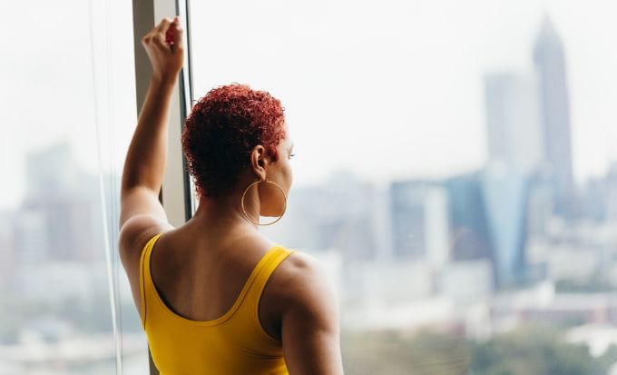 woman looking out of a window reflecting concept criminal injury sexual abuse domestic abuse feature