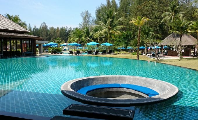 still pool with sunloungers in the background with round seat in the middle in thailand concept accidents abroad swimming pool compensation claims feature image