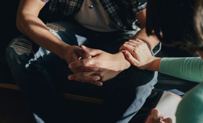 people holding hands to support each other