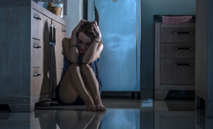 woman with head in hands on floor