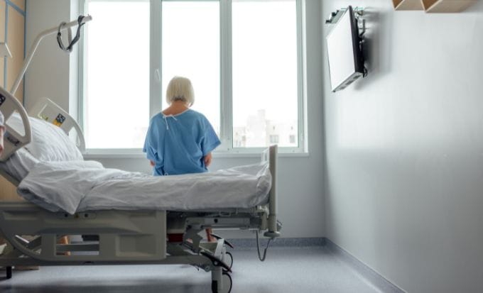 woman on the edge of her hospital bed concept medical negligence surgical negligence feature