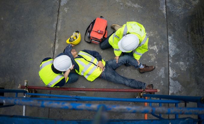 man receiving first aid treatment after an accident at work concept personal injury fall at work accident at work feature