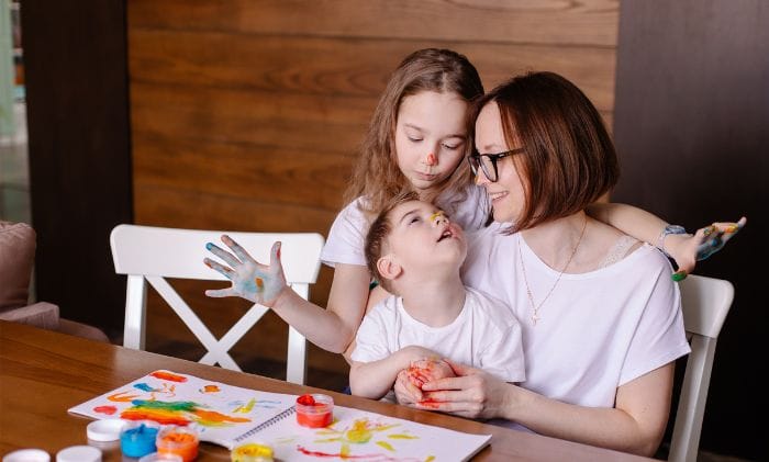 happy-mother-daughter-and-son-suffering-from-cerebral-palsy-painting-with-paint-on-noses-representing-court-of-protection-services