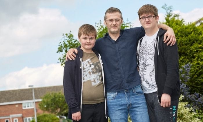 family being supported by case worker arms around family