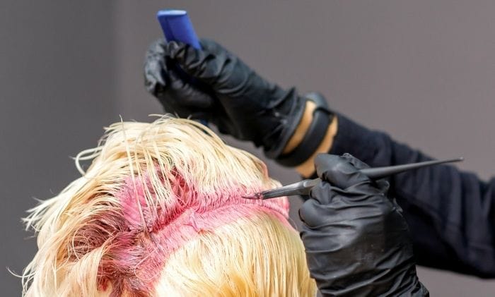 hairdresser-colors-female-blonde-hair-in-pink-color-concept-representing-personal-injury-beauty-&-hairdressing-negligence-compensation-claims