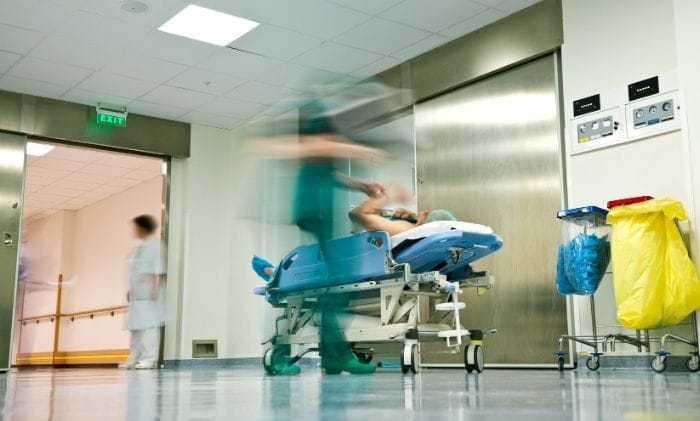 hospital-trolley-in-corridor-nurses-rushing-about-concept-representing-medical-negligence-accident-&-emergency-compensation-claims