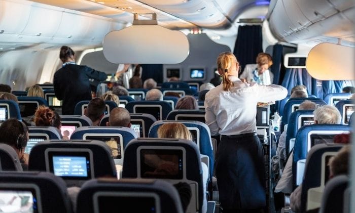 interior of large commercial airplane with flight attandants serving passengers concept representing accidents and injury abroad airplane accidents compensation claims