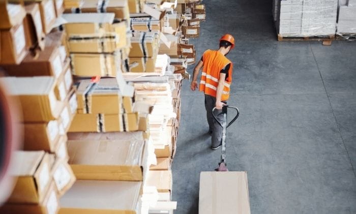 male-worker-in-uniform-in-warehouse-pulling-pallet-truck-concept-representing-personal-injuryaccidents-&-injury-at-work-compensation-claims