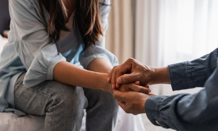 woman-man-couple-holding-hands-comforting-eachother-concept-representing-medical-negligence-failed-vasectomy-&-sterilisations-compensation-claims