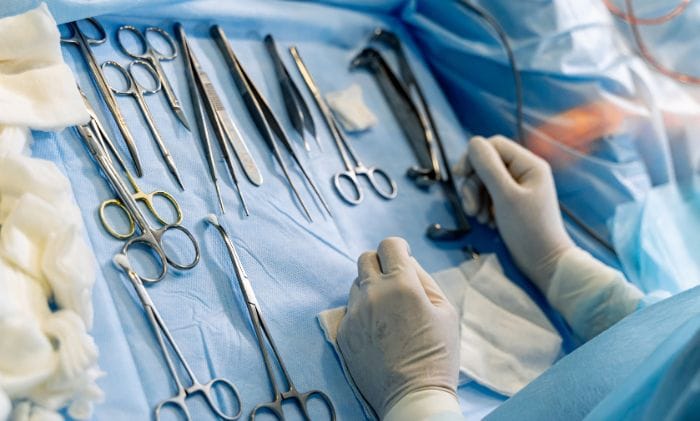 surgical-table-scalpels-clamps-in-operating-room-prepared-medical-instruments-concept-medical-negligence-never-events-retained-surgical-items-compensation-claims
