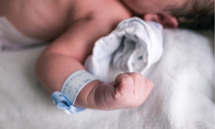 close up of newborn baby hand clenched in hospital concept medical negligence birth injury