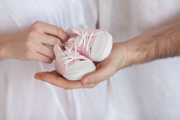 parents hold baby shoes following stillbirth of their child